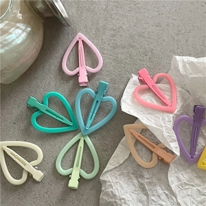 Vue détaillée des barrettes en forme de cœur couleurs macaron avec finition mate sur pierre