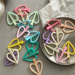 Gros plan de barrettes colorées en forme de cœur évidé aux tons pastel de macaron
