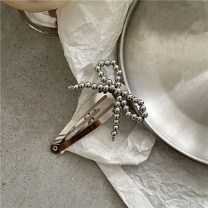 Detailed view of a silver bead bow hair clip with a metallic water drop BB clip design