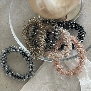 Dettaglio di elastici per capelli in perline di cristallo sfaccettato in oro e grigio