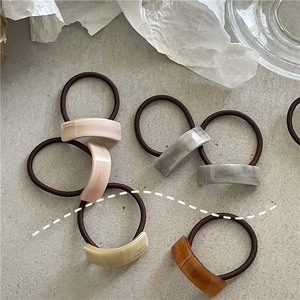 Detailed close-up of acetate geometric hair ties with France Handmade engraving