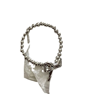 Silver beaded bracelet featuring a metallic bow charm on a clean white background