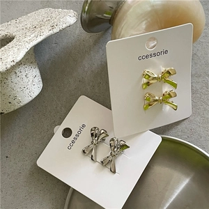 Mini barrettes nœuds métalliques chics en doré et argenté sur cartes de présentation