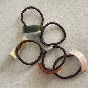 Set of five geometric acetate ponytail holders in assorted colors with handmade lettering