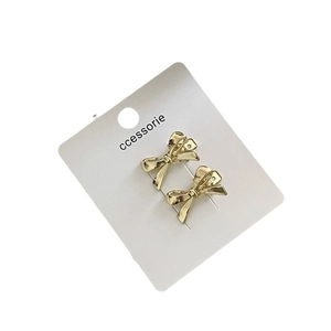 Barrette à cheveux en métal doré avec nœud papillon sur carte de présentation