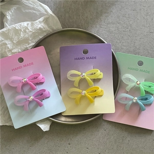Barrettes à cheveux nœud dégradé couleur macaron avec strass sur un plateau décoratif