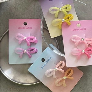 Vue détaillée de barrettes nœuds papillon dégradées avec des pierres précieuses brillantes