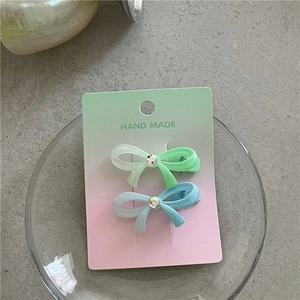 Vue détaillée de barrettes nœuds vert menthe et bleu clair avec des strass brillants