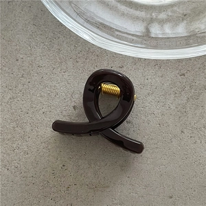 Close-up of a dark coffee jelly hair claw clip with interlocking spiral design