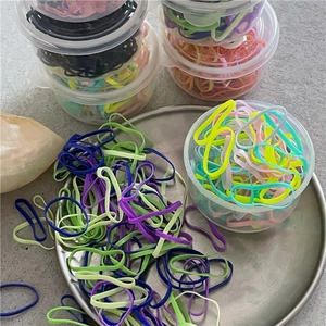 Dettaglio di elastici per capelli colorati per bambini in una scatola di plastica trasparente