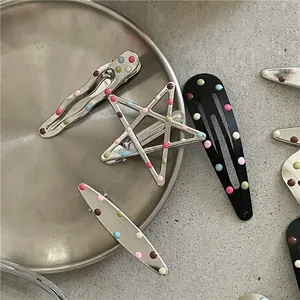 Dettaglio di fermagli per capelli colorati a pois a forma di stella e goccia d'acqua