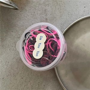 Dettaglio di elastici per capelli colorati per bambini in scatola tonda trasparente