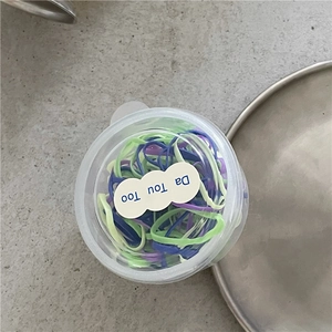 Vista dall'alto di elastici per capelli colorati in un barattolo di plastica per bambini