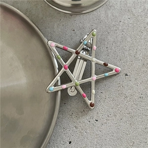 Dettaglio del fermaglio a stella con puntini smaltati colorati e clip a becco d'anatra argento