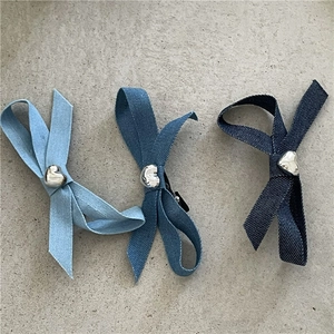 Trois barrettes nœuds en denim avec accents de cœur en métal dans divers tons de bleu