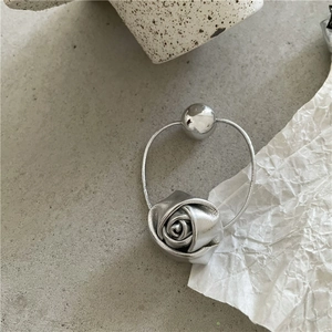 Detail of silver metallic rose and polished bead on an elastic spiral hair tie