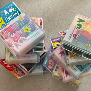 Detail of colorful elastic hair bands for babies in a clear square plastic box