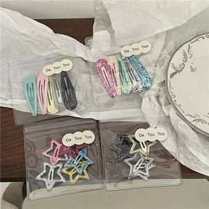Détails macro d'un lot de barrettes à paillettes en forme de goutte et d'étoile