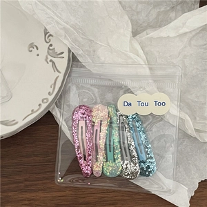 Lot de cinq barrettes à paillettes BB aux couleurs irisées dans un sac dépoli