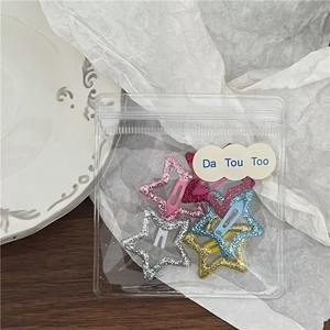 Vue détaillée de cinq barrettes étoiles à paillettes dans un sachet transparent