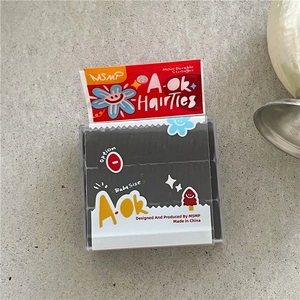 Detail view of black baby-size elastic hair ties in a compact transparent storage box