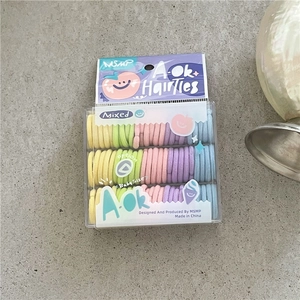 Macro view of colorful macaron elastic hair bands set for babies in a clear plastic box