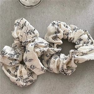 Floral off-white fabric scrunchies with black plant patterns and lace embroidery edges