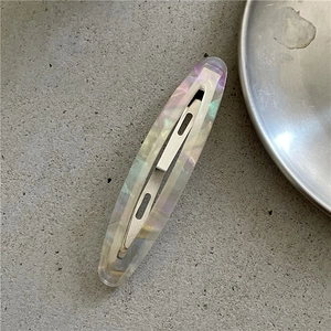 Close-up of iridescent marble acetate hair clip with polished silver metal fastener