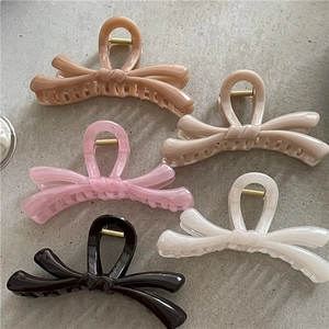 Detailed view of five large jelly bow hair claws in vibrant colors with gold springs