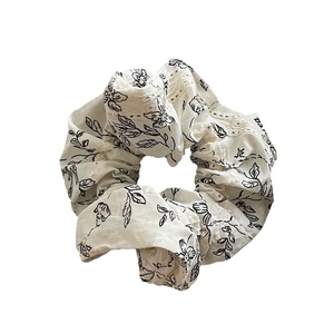 Elegant off-white floral scrunchie with black botanical print and delicate lace trim edge