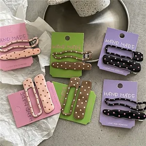 Set of sweet polka dot alloy hair clips in various shapes on decorative card packaging