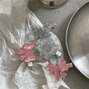 Pink marble and clear glitter resin bow hair clips set on a stylish minimalist background