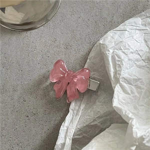 Detail of pink translucent resin bow hair clip with silver metal snap fastener