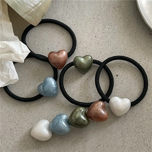 Set of minimalist elastic hair ties featuring colorful pearlescent heart charms