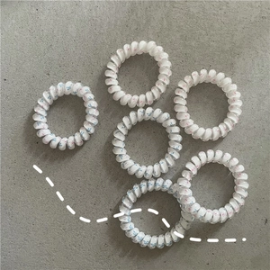 Detail of six spiral telephone cord hair ties with delicate pink and blue floral patterns