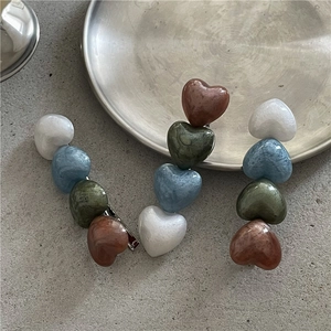 Detailed close-up of acetate heart beaded hair clips with elegant vintage texture