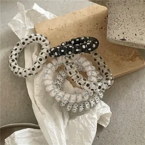 Polka dot spiral hair ties and floral telephone cord hair rings on a stone tray