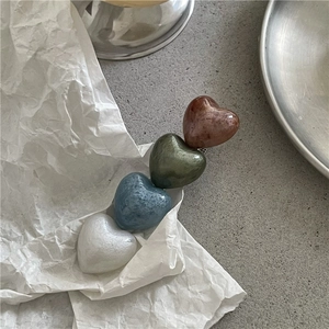 Detailed close-up of colorful heart-shaped hair clips with smooth pearlescent texture