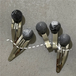Detailed set of marble pattern bead hair clips with golden metallic finish and geometric balls