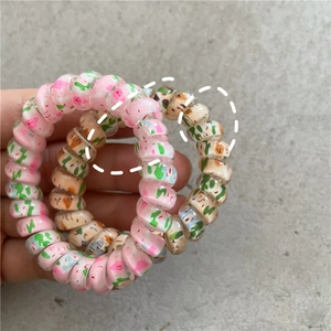 Detailed macro view of spiral telephone cord hair ties with spring floral graffiti patterns