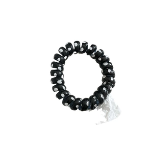 Elastic black and white polka dot spiral hair tie with a minimalist phone cord design