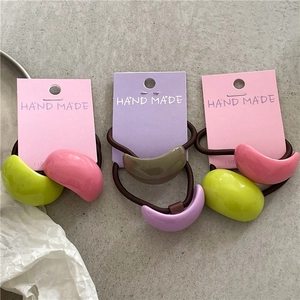 Detail of crescent resin hair ties in pastel colors on decorative brand display cards