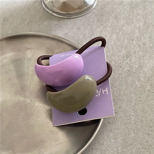 Detail of lavender and olive green semi-circular hair ties on display card