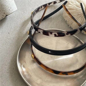 Detail showing non-slip teeth and gold alloy beads on leopard pattern headbands