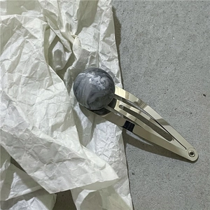 Close-up of marble texture sphere hair clip with polished silver metal BB clip