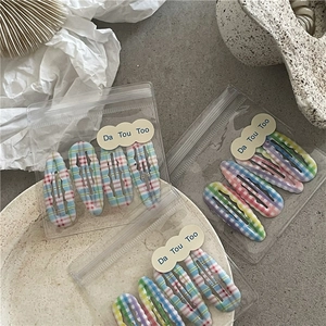 Gros plan de barrettes à cheveux à carreaux colorés dans des sacs zippés