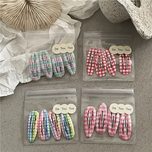 Détail de barrettes à cheveux BB à motif écossais coloré dans un emballage cadeau