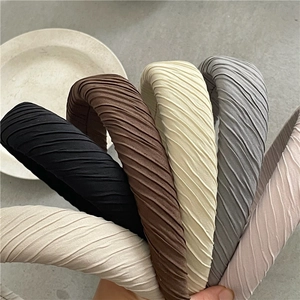 Gros plan de serre-têtes en tissu plissé en plusieurs couleurs avec rembourrage épais