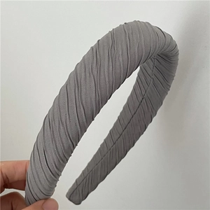 Détail d'un serre-tête en tissu plissé gris avec rembourrage en éponge pour volume