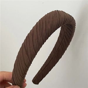 Vue détaillée du tissu plissé marron foncé sur ce serre-tête rétro épais rembourré